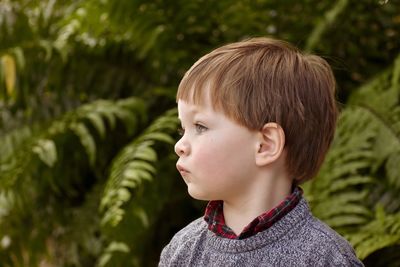 Portrait of cute boy looking away outdoors