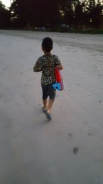 Rear view of boy running on land