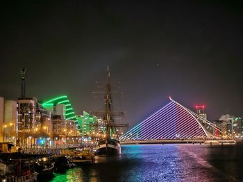 Illuminated bridge over river at night