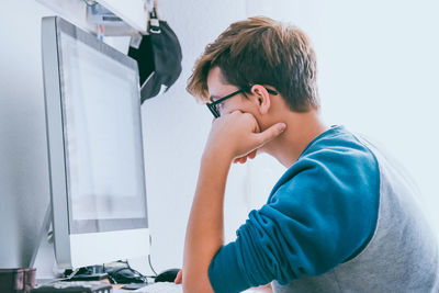 Student using computer at home, doing homework. teenager studying online. homeschooling concept.