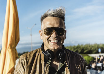 Portrait of smiling man wearing sunglasses against sky
