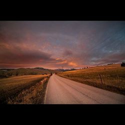 Country road against cloudy sky