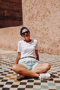 Portrait of young woman sitting at poolside