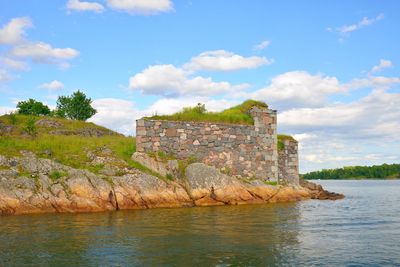 Built structure on riverbank against sky