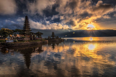 Panoramic view of temple by building against sky during sunset