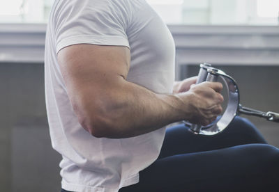 Midsection of man exercising in gym