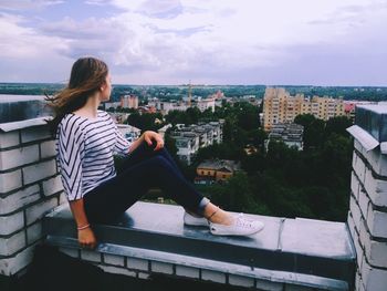 Side view of a woman overlooking cityscape