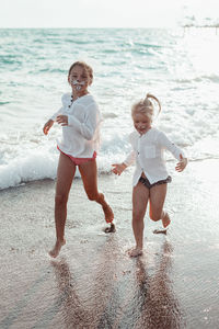Rear view of boy standing at beach