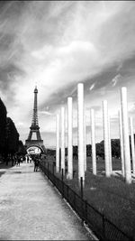 Tower in city against cloudy sky