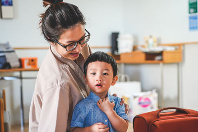 Happy mother with son standing at home