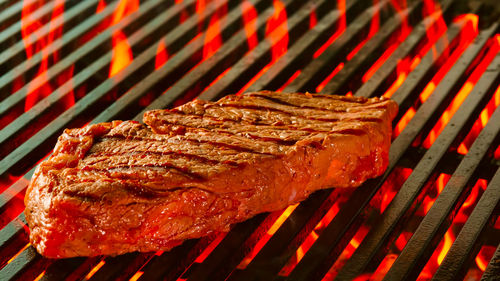 Beef steak on grill with rosemary pepper and salt