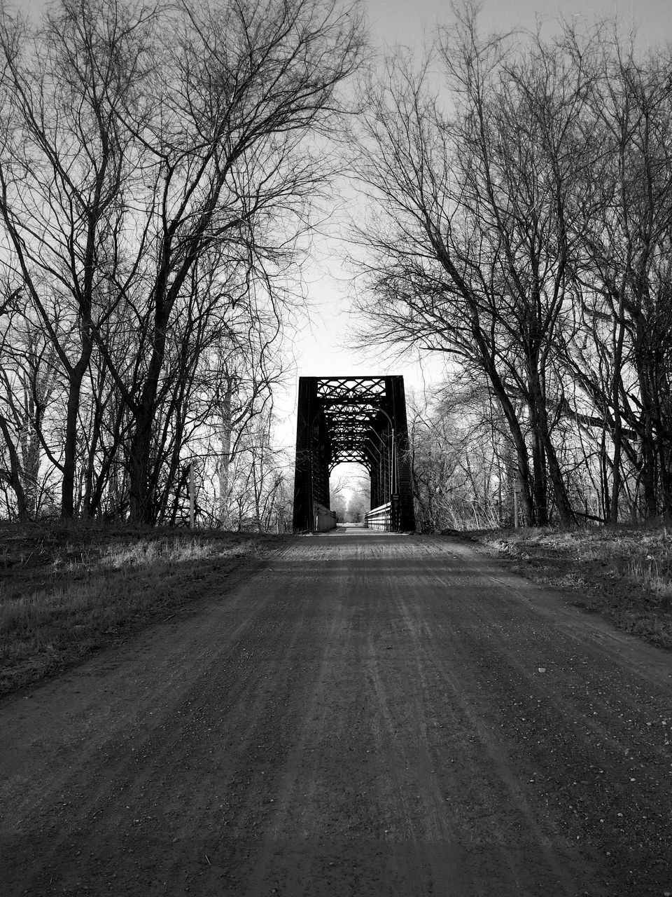 the way forward, bare tree, tree, transportation, road, diminishing perspective, vanishing point, empty, built structure, tranquility, street, silhouette, sky, outdoors, country road, nature, architecture, one person, day, branch