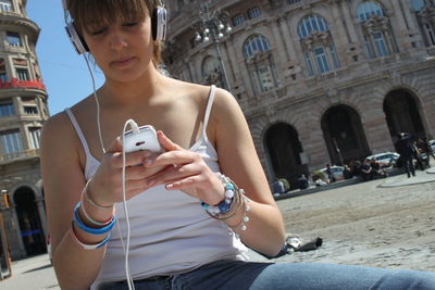 Midsection of man using mobile phone in city