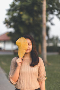 Young woman holding ice cream standing outdoors