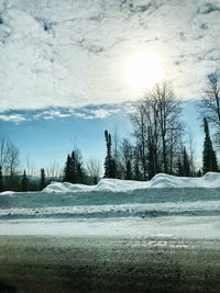 Scenic view of snow covered field against sky