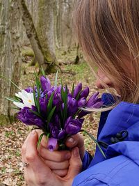 Woman holding purple flowering plants