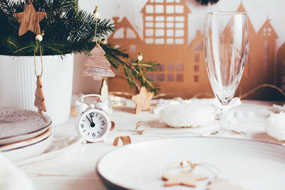  white alarm clock, plates, spruce bouquet and christmas decor