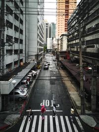 Vehicles on road amidst buildings in city