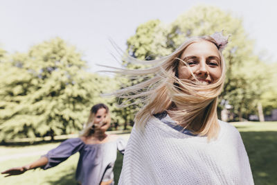 Portrait of two happy young women running in a park
