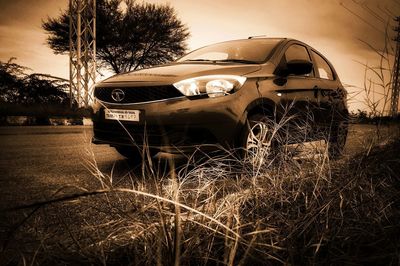 Abandoned car on field against sky