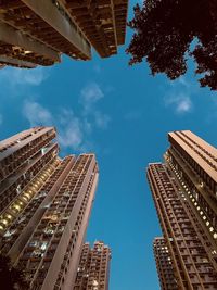 Low angle view of skyscrapers against blue sky