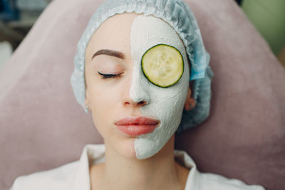 Close-up of woman applying face mask at spa