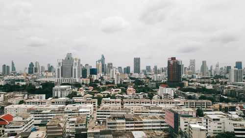 Aerial view of buildings in city against sky