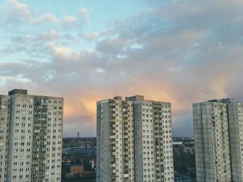 Modern buildings against cloudy sky