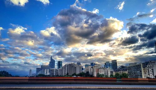 View of cityscape against cloudy sky