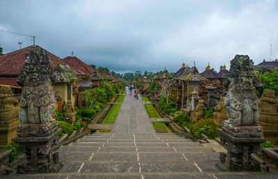 Statues amidst buildings against sky