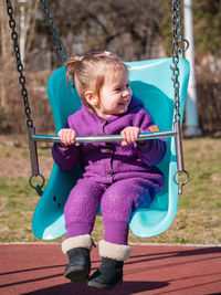 Portrait of boy swinging at playground