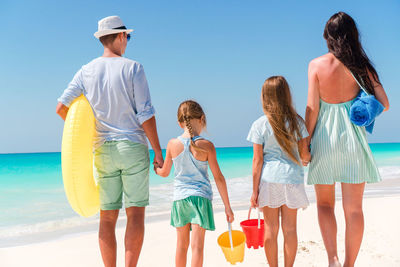 Rear view of family standing on beach