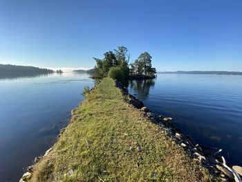 Scenic view of lake against clear blue sky