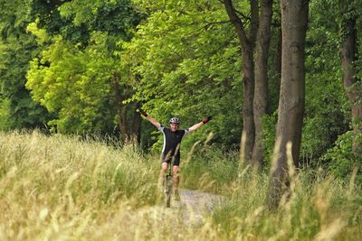 Full length of man with arms raised in park