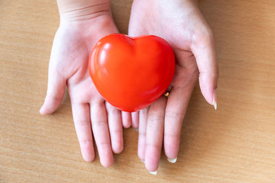 Midsection of woman holding red heart