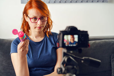 Portrait of young woman sitting on sofa