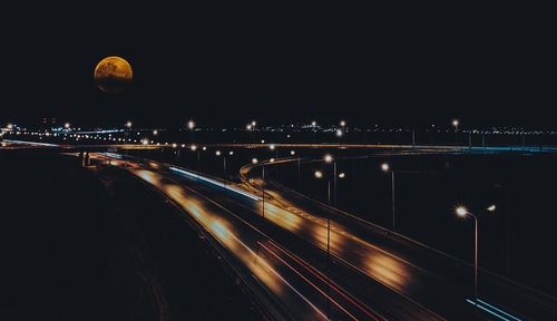 Light trails on bridge in city at night