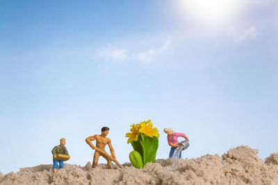 Low angle view of people at beach against sky