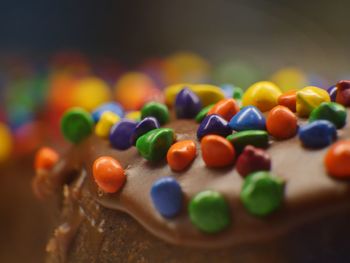 Close-up of multi colored candies on chocolate cake