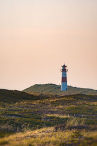 Lighthouse on land against sky