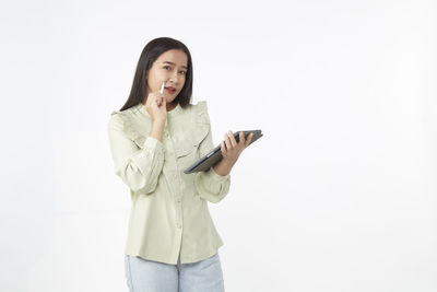 Young woman using smart phone against white background