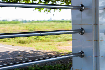 Close-up of railing on field seen through window