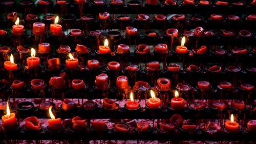 Full frame shot of burning candles in temple