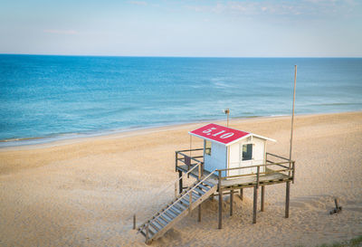 Lifeguard hut on beach against sky