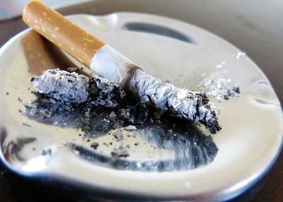 Close-up of burnt cigarette on ashtray