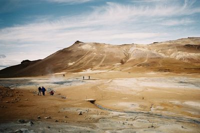 High angle view of people at geyser by mountain 