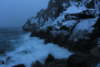 Scenic view of rocks in sea against sky