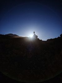 Low angle view of silhouette person against clear blue sky