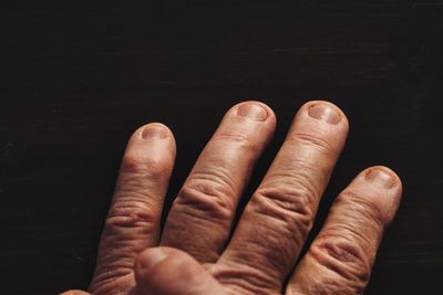 Close-up of human hand against black background