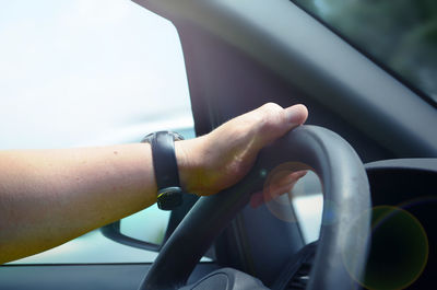 Close-up of man driving car against sky